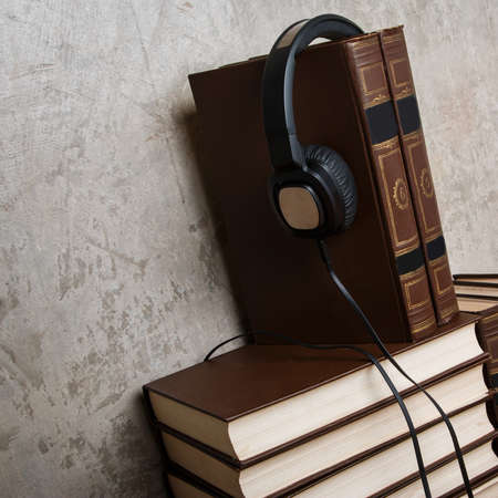 Audiobooks concept. Old books and black headphonesの写真素材