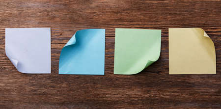 Multicolored paper stickers on wooden tableの写真素材