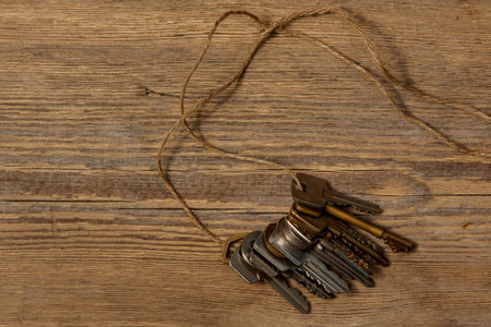 Different keys on thread over wooden surface
