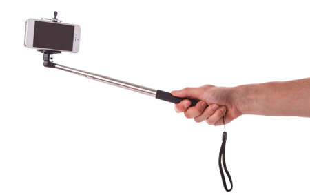 Smart phone on a selfie stick over white backgroundの写真素材
