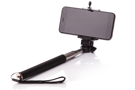 Smart phone on a selfie stick over white background