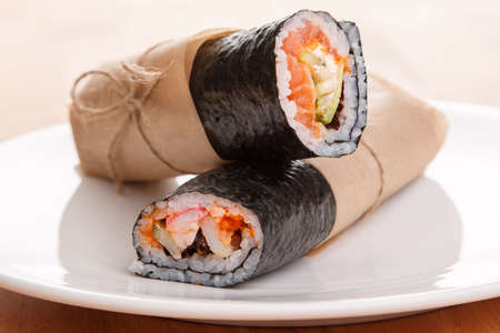 Sushi burrito - new trendy food concept. Sushi burrito rolls on the plateの写真素材