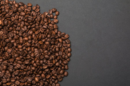 Coffee beans on a grey paper surface