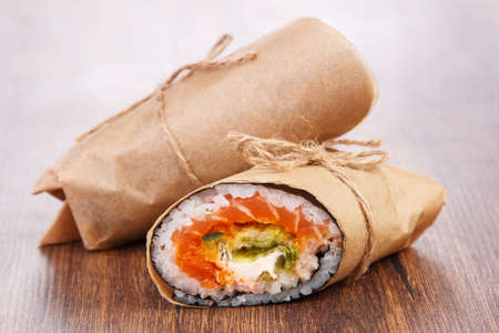 Sushi burrito - new trendy food concept. Sushi burrito rolls on wooden surfaceの写真素材
