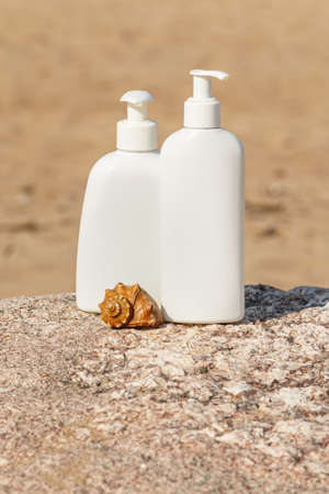 White bottles of cosmetics on the beachの写真素材