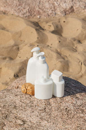 White bottles of cosmetics on the beachの写真素材