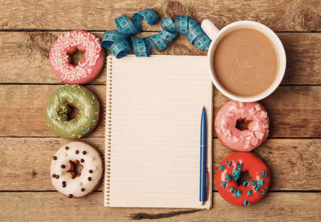 Diet concept. Colorful donuts and notepadの写真素材
