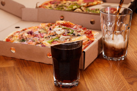 Glass of coke and pizza on the table