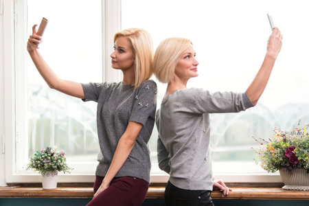 Mother and daughter taking a selfie at home