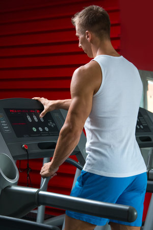 Young man on treadmill in the gym