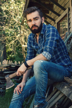 Handsome bearded man in checkered shirt with axeの写真素材