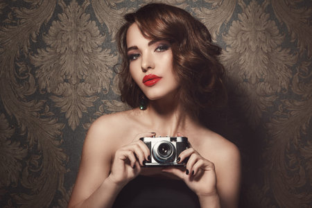 Beautiful woman with a vintage camera in handsの写真素材