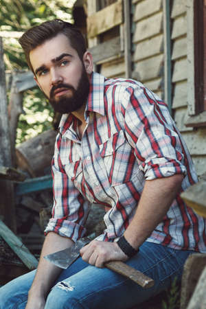Handsome bearded man in checkered shirt with axeの写真素材