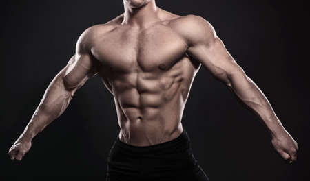 Muscular male torso on black backgroundの写真素材