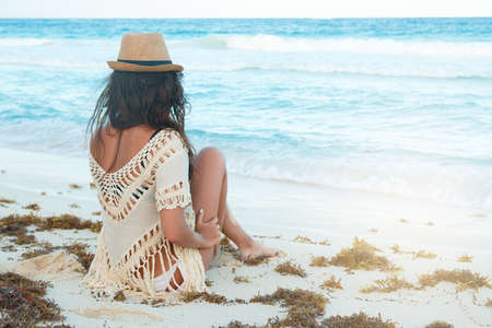 Young and beautiful woman wearing a hat on the beachの写真素材
