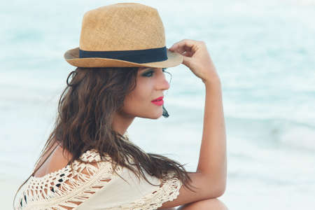 Young and beautiful woman wearing a hat on the beachの写真素材