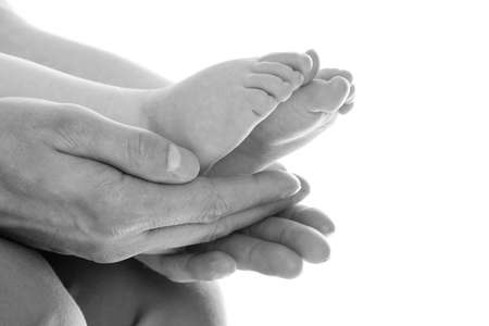 Closeup of father's hands holding baby feetの写真素材