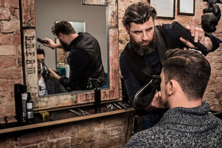 Hairdresser during work with a guy client