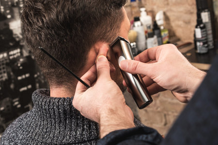 Close-u of hairdresser is working with a hair-clipper