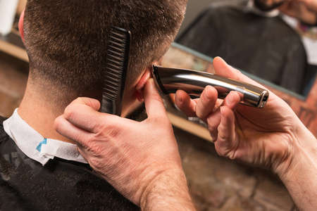 Close-u of hairdresser is working with a hair-clipperの写真素材