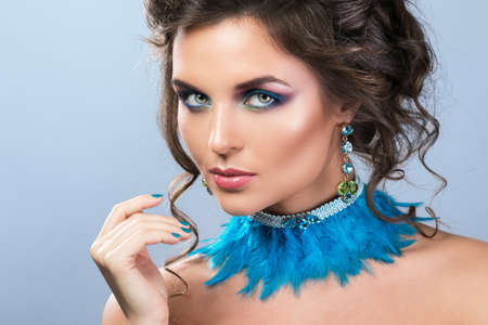 Gorgeous woman with wearing  beautiful earrings and necklace made from feathersの写真素材