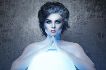 Woman with creative makeup and body-art in image of a soothsayer