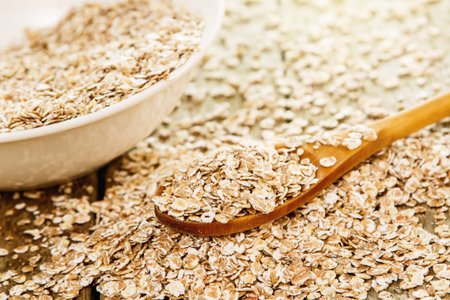 Uncooked oatmeal and wooden spoon. The best grain for breakfast.