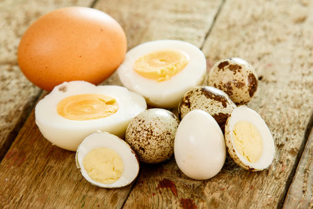 Quail and chicken eggs on wooden table