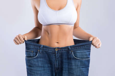 Woman after weight-loss is try her old jeansの写真素材