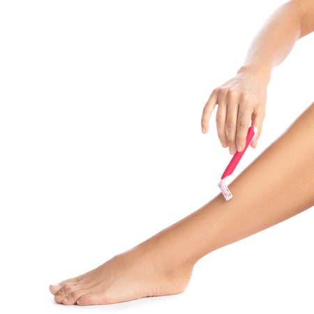 Female legs and shaving razor on white backgroundの写真素材