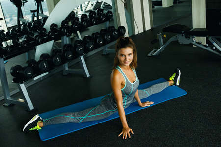 Woman doing stretching exercise in the gymの写真素材