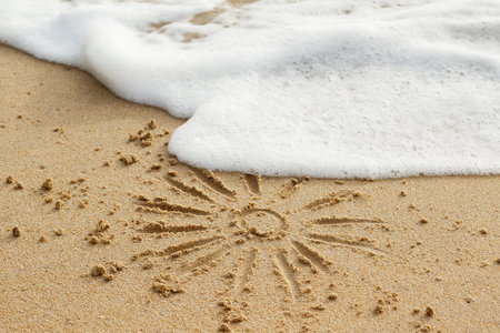 Drawing of sun on the sand and wave foam