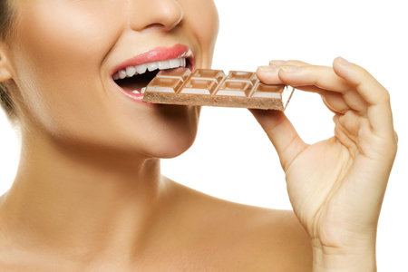 Female mouth and chocolate bar on white background
