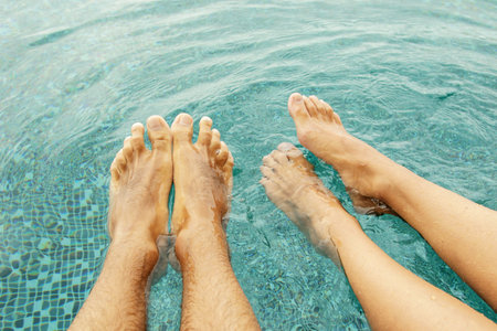 Male and female legs in the swimming pool