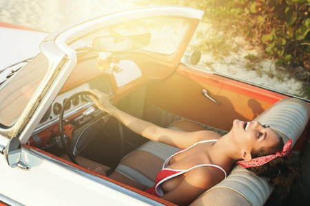 Beautiful and happy woman inside retro cabriolet car