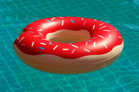 Inflatable swim ring in shape of a donut in the poolの写真素材