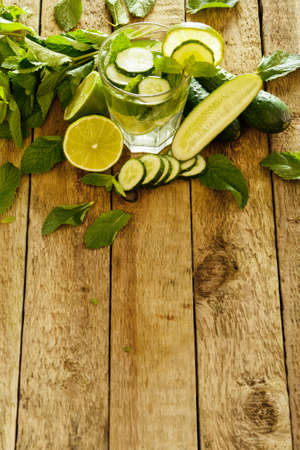 Refreshing drink with cucumber, lime and mint on wooden tableの写真素材