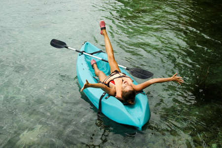Happy woman relax during lying in the kayakの写真素材