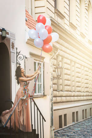 Lovely woman in beautiful dress with a lot of colorful balloonsの写真素材
