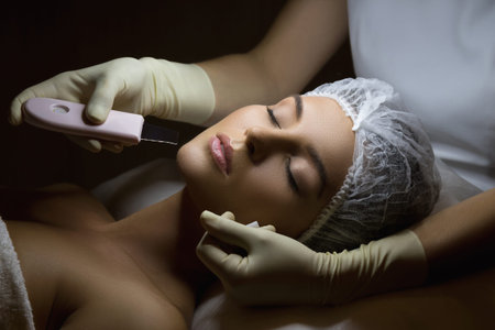 Beautiful woman in professional beauty spa salon during ultrasonic facial cleansing procedure
