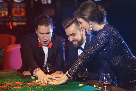 Group of young rich people playing roulette in the casinoの写真素材