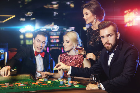 Young, well dressed and rich people playing roulette in the casino
