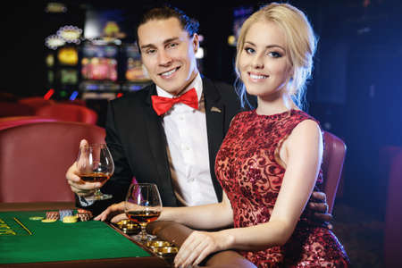 Beautiful well dressed couple playing roulette in the casinoの写真素材