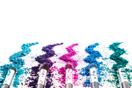 Crushed eyeshadows and make-up brushes on white backgroundの写真素材