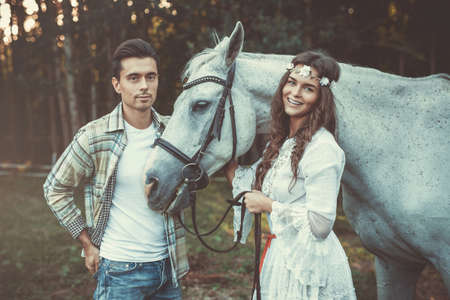 Young couple taking care about  beautiful horseの写真素材