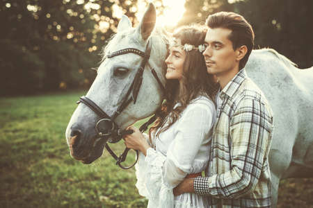 Young couple taking care about  beautiful horseの写真素材