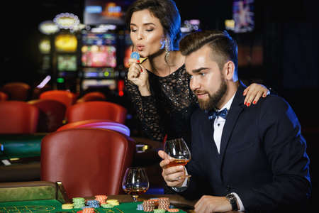 Beautiful and well dressed couple playing roulette in the casinoの写真素材