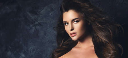 Portrait of stunning woman with a beautiful curly hair and professional makeupの写真素材