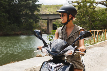 Woman driving scooter on old rural road in the mountains