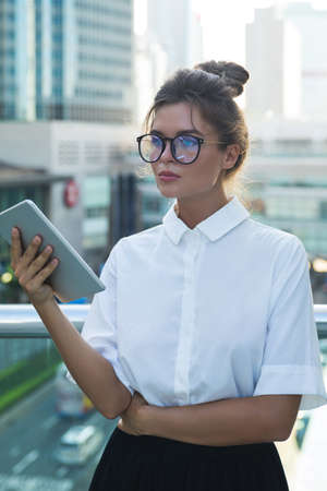 Woman wearing smart casual clothing is using tablet pcの写真素材